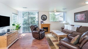 A spacious living room with a leather sofa, a leather recliner, a wooden coffee table, and a fireplace. - Telluride Lodge 305 by Avantstay Close to Slopes & Town! (Telluride)
