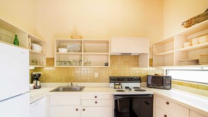 A compact kitchen with white cabinets, a stove, microwave, and a sink. - Telluride Lodge 305 by Avantstay Close to Slopes & Town! (Telluride)