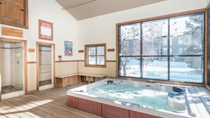 A spa room with a hot tub, wooden benches, a glass shower enclosure, and a large window with a view of a snowy landscape. - Telluride Lodge 305 by Avantstay Close to Slopes & Town! (Telluride)