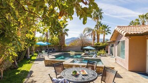 Un jardin avec une piscine, du mobilier de jardin et une vue sur les montagnes.