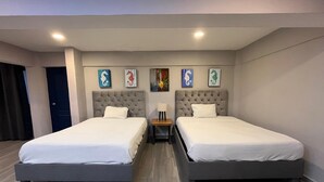 A hotel room with two beds, a nightstand, and artwork on the wall. - Hermoso estudio en Cozumel 5 (Cozumel)