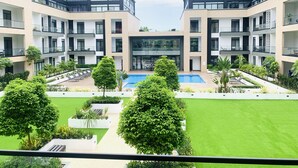 Ein moderner Apartmentkomplex mit Innenhof, Schwimmbad und üppiger Bepflanzung.
