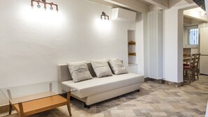 A modern living room with a glass coffee table, a white sofa with cushions, a wooden bench, and a herringbone-patterned floor. - S291 - Sirolo, new three-room townhouse in the historic centre (Sirolo)
