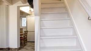 A staircase leading to a second floor, a dining area with chairs and a table, and a radiator. - S291 - Sirolo, new three-room townhouse in the historic centre (Sirolo)
