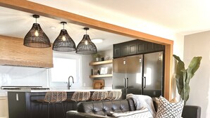 A modern living room with a leather sofa, a coffee table, and a large plant. - Upper Rideau - “The West” Resort (Portland)