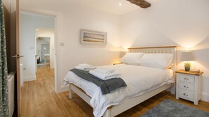 Un dormitori amb un llit, taules de nit, una làmpada i un quadre a la paret.
