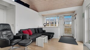 A modern living room with a leather chair, grey sofa, and a white coffee table. - 3 bedroom amazing home in Mariager (Mariager)
