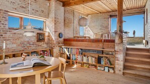 Un angolo accogliente per la lettura, con un tavolo in legno, scaffali e una poltrona comoda.