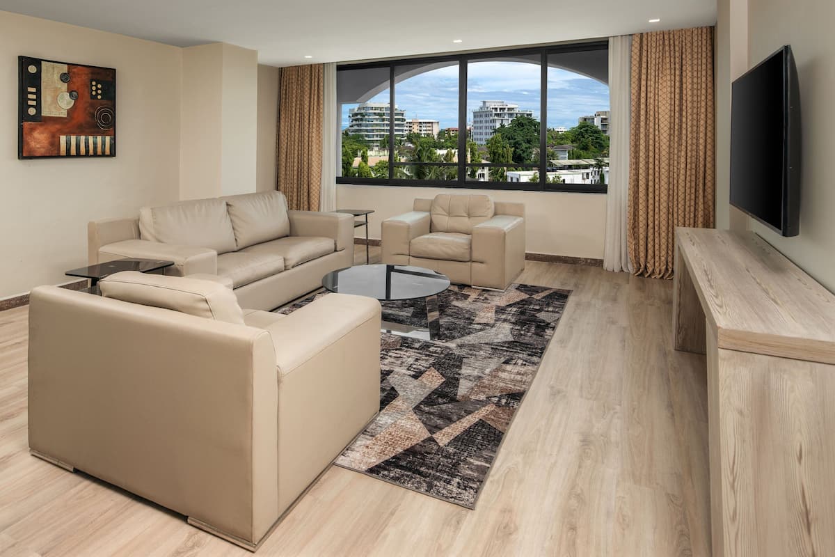 Un salon moderne comprenant un ensemble de canapés, une table basse et un téléviseur fixé au mur.
