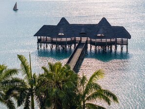 A pier extending into a body of water with a thatched-roof structure at the end. - Delta Hotels Dar es Salaam (Dar es Salaam)