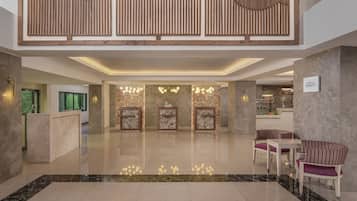 A modern lobby with a reception desk, seating area, and a bar.