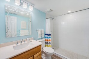 Un baño con tocador, espejo, inodoro y ducha.