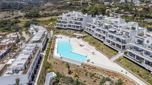 A modern resort with a central swimming pool, multiple balconies, and a landscaped garden. - Sonrisa | Sea view - pool - terrace (Estepona)