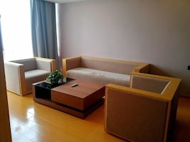 Una sala de estar moderna con un sofá, dos sillones y una mesa de centro.