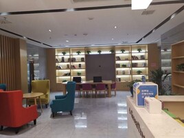 Una biblioteca moderna con estanterías, un mostrador de recepción y zonas de estar.