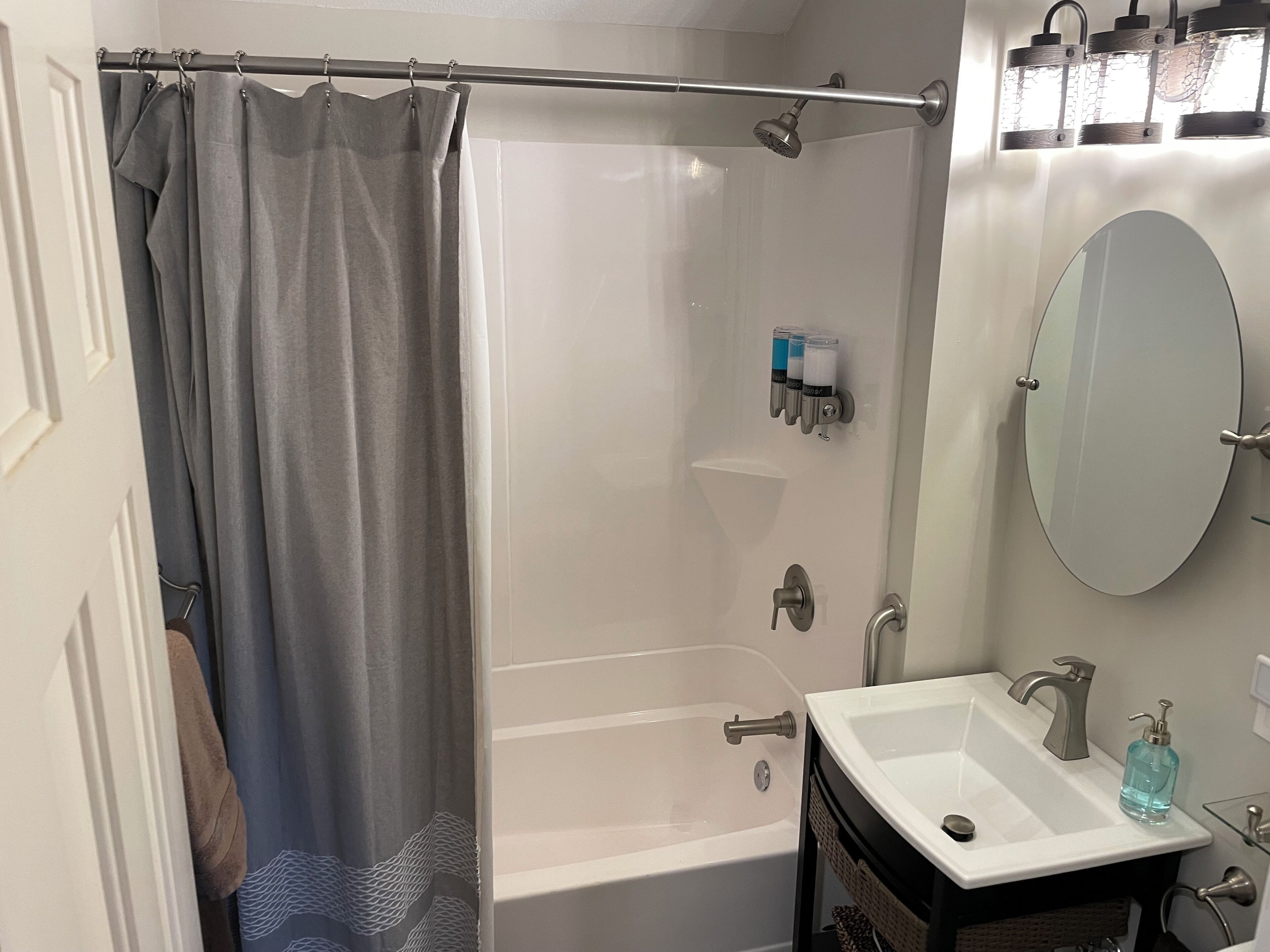 A modern bathroom with a shower, a bathtub, a sink, and a mirror.