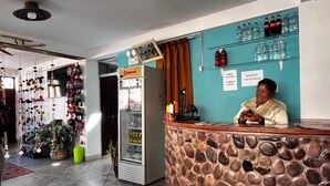 A reception area with a stone counter, a refrigerator, and a wall-mounted beverage dispenser. - Casa D Maria (Ollantaytambo)
