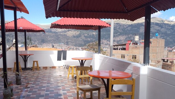 Une terrasse agrémentée de parasols rouges, dotée d’un sol carrelé et de mobilier en bois.