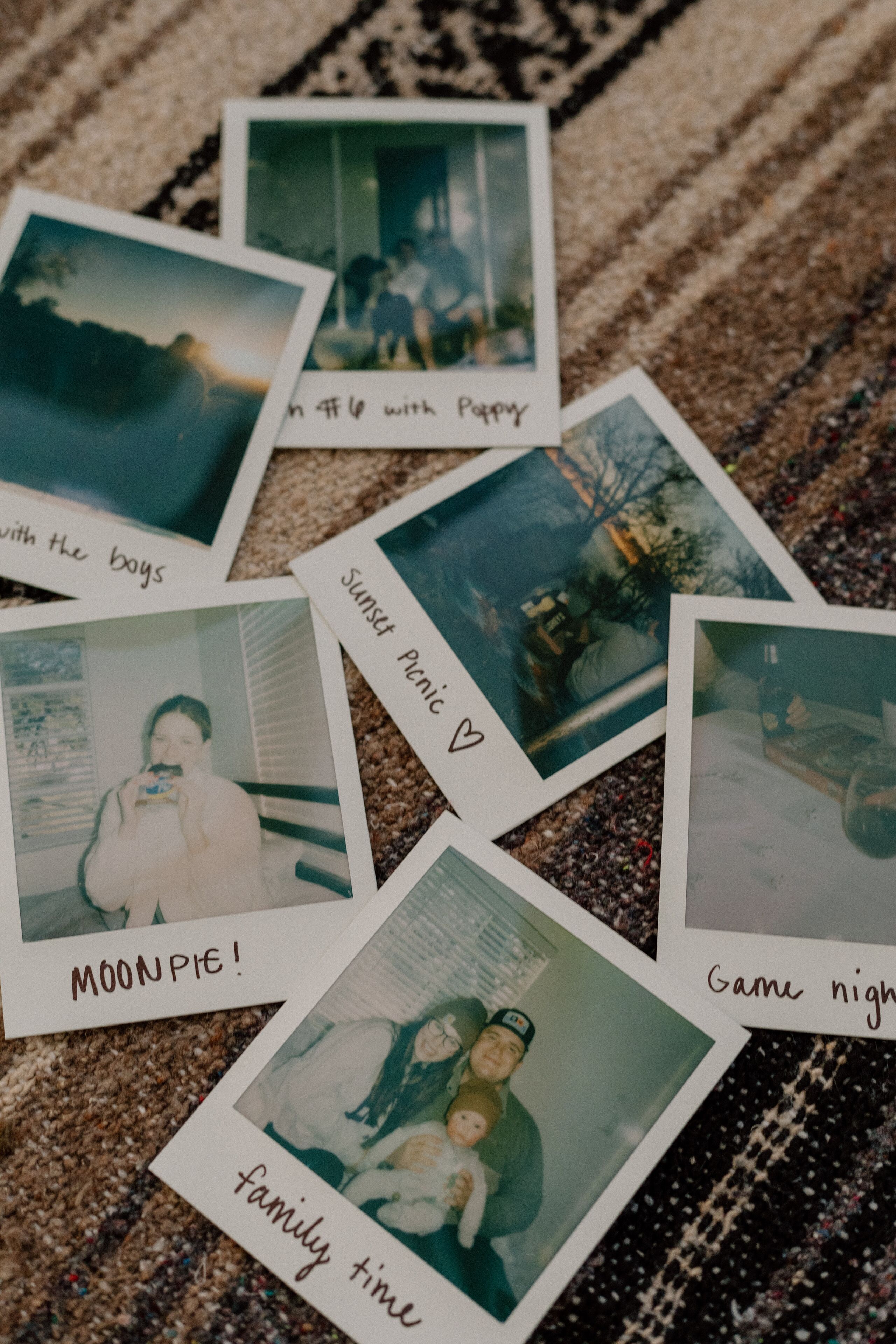 A collection of polaroid photos with captions on a textured surface.
