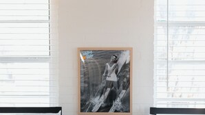 A bedroom with two beds, a small table with a cactus, and a framed picture on the wall. - Whitney Ridge Resort (Clifton)