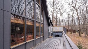 Una terraza de madera con ventanas amplias y un jacuzzi.