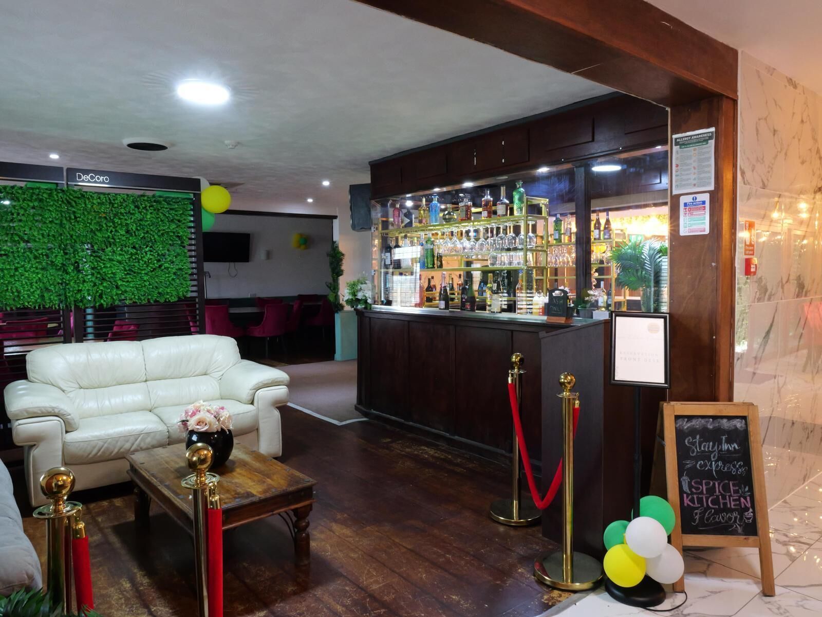 A bar area with a counter, stools, and a menu board.
