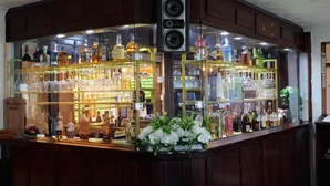 A bar area with shelves of liquor bottles and glasses, a speaker, and a sign labeled 'Boutique Beers'. - Stay Inn Express (Cambridge)