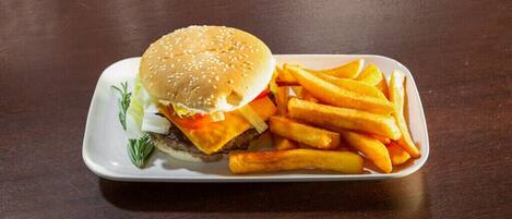 Un plato con una hamburguesa y papas fritas sobre un plato blanco rectangular.