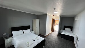 A hotel room with two beds, a wardrobe, a desk, and a chair. - Stay Inn Express (Cambridge)