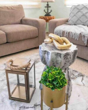 Relax in this inviting living room with a comfortable sofa, a rustic table, and a potted plant.