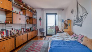 Une chambre confortable avec un grand lit, un bureau et une bibliothèque remplie de livres.