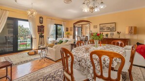 Un coin repas avec une table ronde, des chaises et un lustre.
