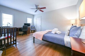 A bedroom with a bed, a desk, a chair, a crib, and a ceiling fan. - Spacious Central San Jose SFH 3BR w/crib Free park (San Jose)