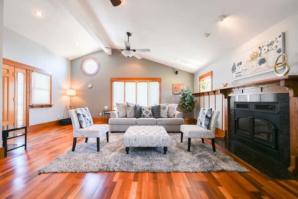 A living room with a sofa, two armchairs, a coffee table, a fireplace, and a ceiling fan. - Spacious Central San Jose SFH 3BR w/crib Free park (San Jose)