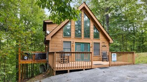 Eine Holzdiele mit Balkon, großen Fenstern und einem Schild, das anzeigt, dass es sich um einen Campingplatz handelt.