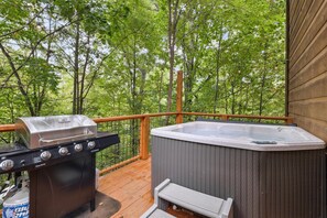 A deck with a Char-Broil grill and a hot tub.