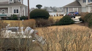 A residential area with houses, a body of water, and a parked car. - Cottage | 3 Min Walk to the Beach (Yarmouth)