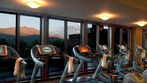 A gym with treadmills and elliptical machines, large windows with a mountain view, and ceiling lights. - Ski-in/out - Grand Lodge Peak 7 - 2 bedroom (Breckenridge)