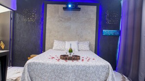 A bedroom with a bed, a ceiling fan, a projector, and a marble floor. - Cascada suite. Private Waterfall Pool & Cinema Screen I Beachfront Sanctuary (Chuburná)