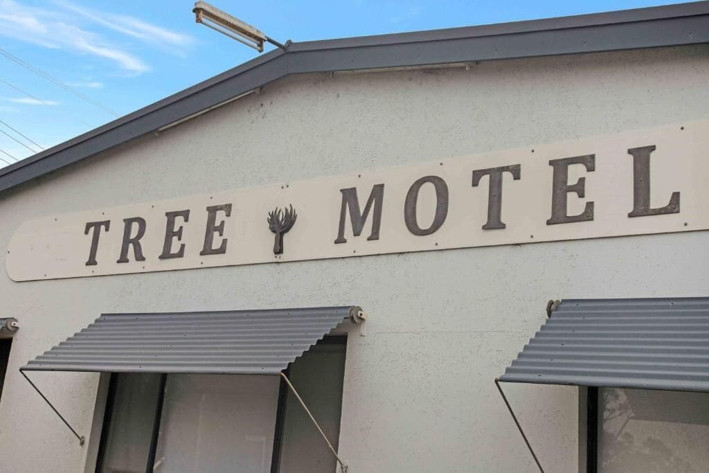 A building with a sign that reads "TREE MOTEL."