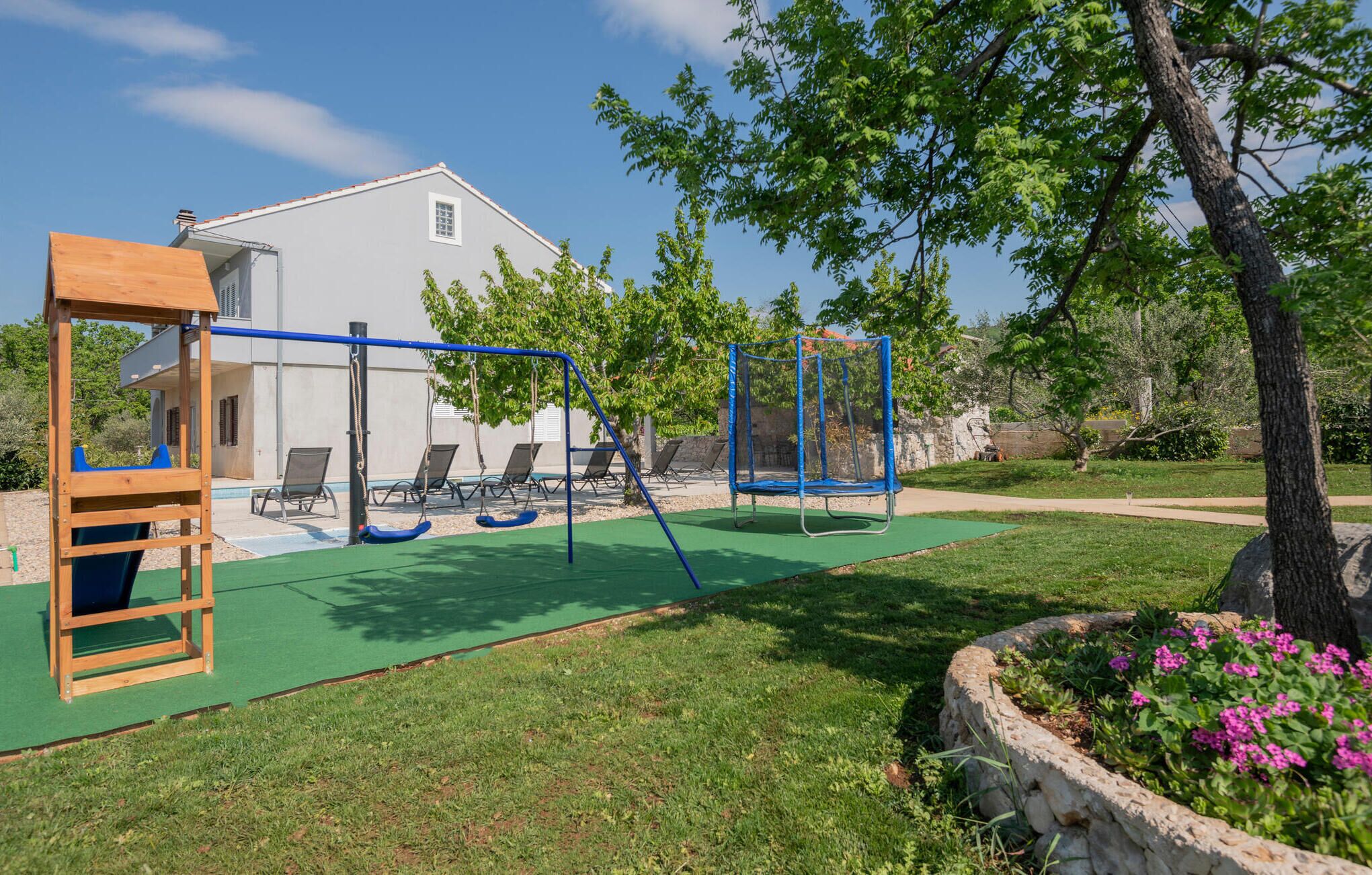 A playground with swings, a slide, and a climbing structure.