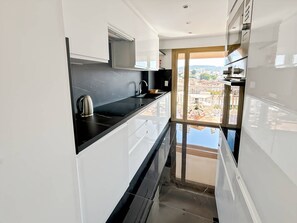 Een koelkast, kookgerei, borden en bestek