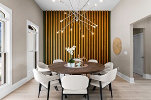 Enjoy meals in this stylish dining area with a round table and six chairs, surrounded by a beautiful centerpiece and elegant lighting.