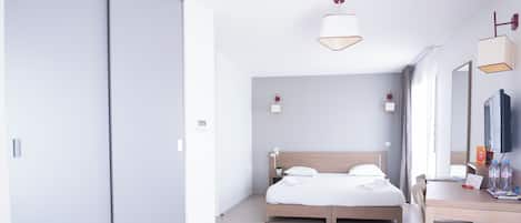 Ein modernes Hotelzimmer mit einem großen Bett, einem Schreibtisch und einem Fernseher.