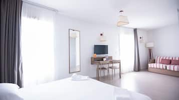 Une chambre d’hôtel avec un grand lit, un bureau avec une télévision et un canapé.