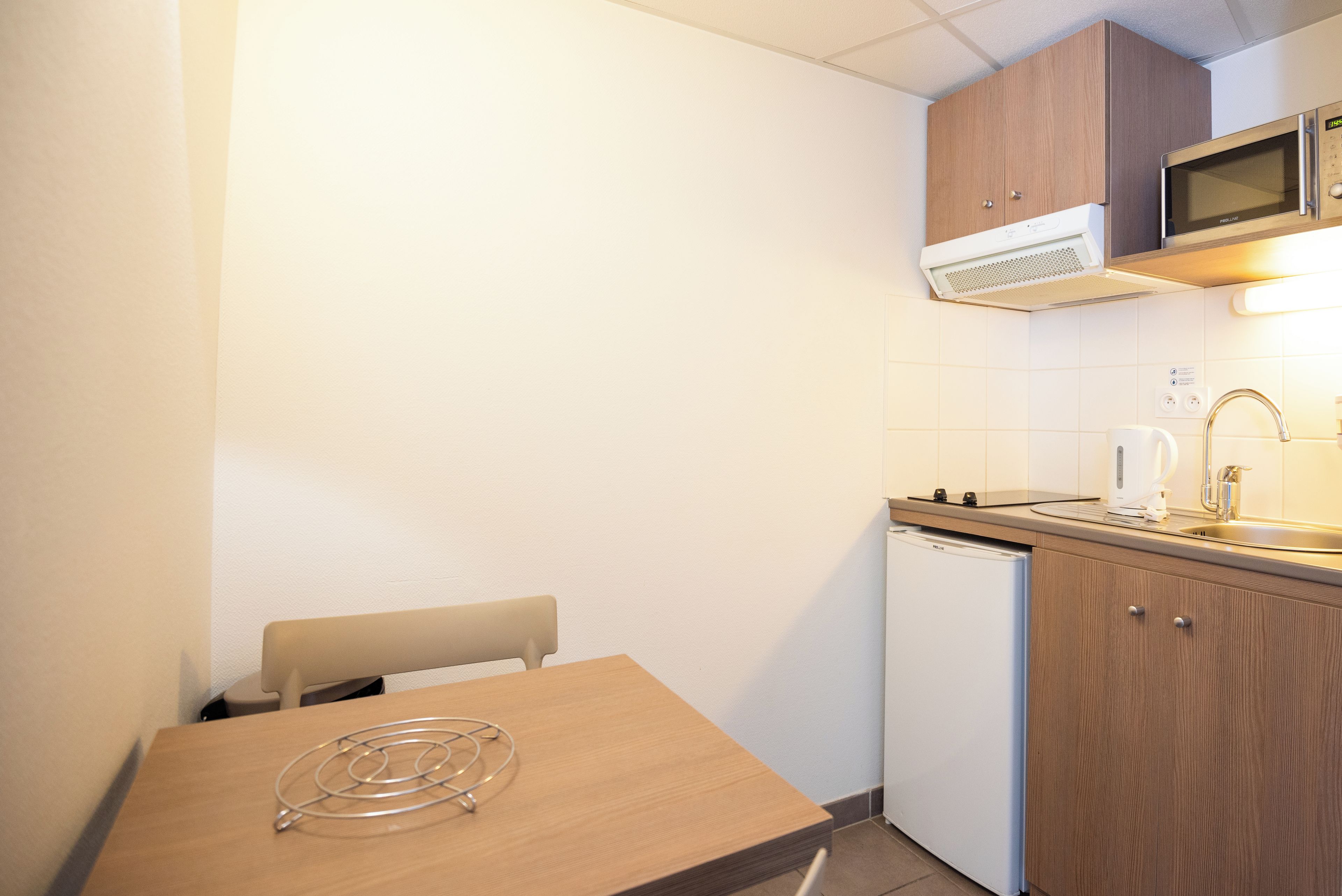 A compact kitchen with a microwave, a coffee maker, and a dishwasher.