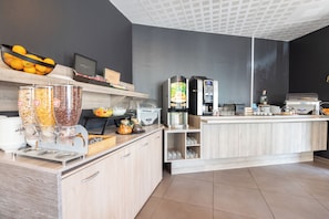 Una cocina moderna con una estación de café, fruteros y una cafetera.