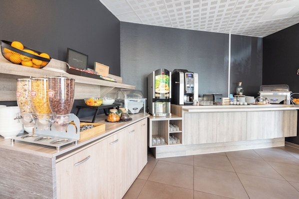 A modern kitchen with a coffee station, a fruit bowl, and a coffee machine.