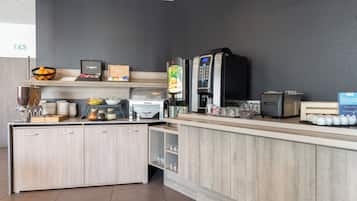 Une cuisine moderne avec un comptoir en bois, une machine à café et un réfrigérateur.