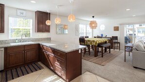 A modern kitchen with granite countertops, wooden cabinets, and pendant lighting.